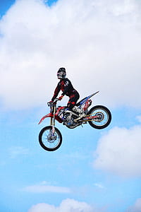 man riding motocross bike in mid air during day thumbnail