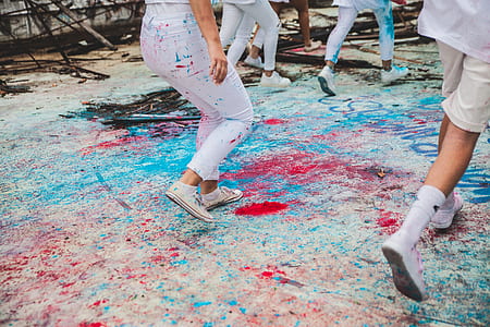 persons playing on gray, blue, and red sand at daytime thumbnail