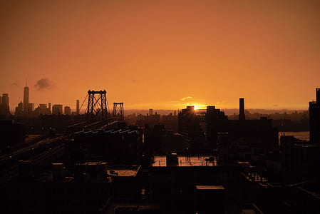 silhouette photo of city buildings at sunset thumbnail