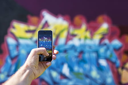 person taking photo of a graffiti filled wall thumbnail