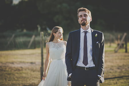 man in black suit jacket beside woman in white sleeveless dress thumbnail
