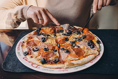person about to slice pizza on plate thumbnail