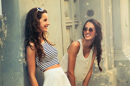 Two brunette women with sunglasses standing on the street thumbnail