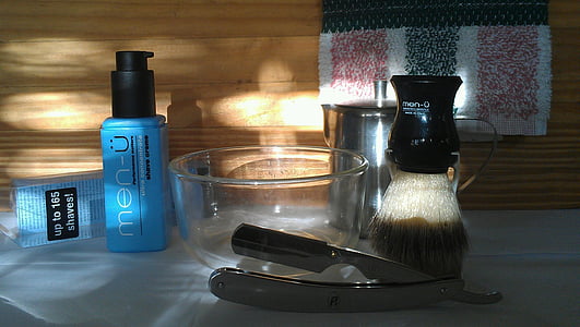 black makeup brush beside bowl, straight razor, and push bottle thumbnail