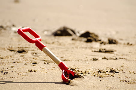 red and white sand shovel on sand thumbnail