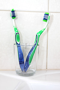 two green toothbrushes in glass thumbnail