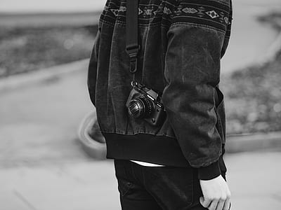 man in black jacket with camera on his back thumbnail