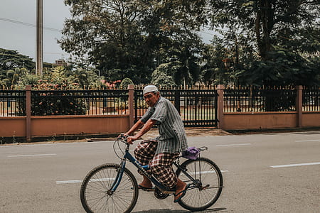 man riding blue bicycle thumbnail