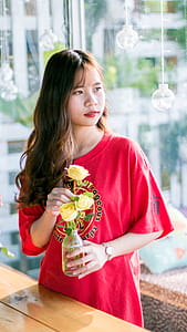 Woman Wearing Pink Scoop-neck Shirt While Holding Yellow Flowers thumbnail