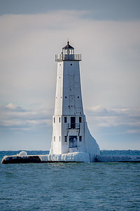 white lighthouse near bodies of water at daytime thumbnail