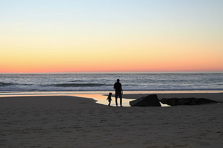 silhouette of man and child on beach during day time thumbnail