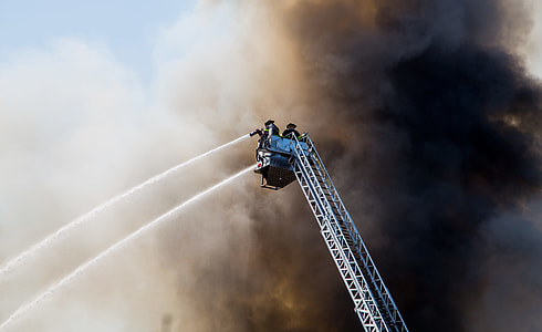 two fireman on manlift truck under black smoke during daytime thumbnail