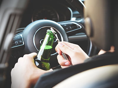 person opening glass bottle inside vehicle thumbnail