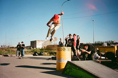 Person in Beige Pants Riding Skateboard over Yellow Metal Barrel thumbnail