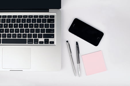 MacBook Pro beside two pens and iPhone thumbnail
