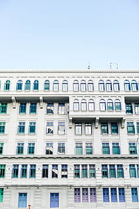 low-angle photography of white concrete high-rise building under blue sky thumbnail