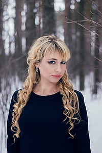 woman in black crew-neck long-sleeved shirt near withered tree with shallow depth of field thumbnail