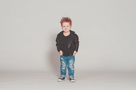 boy standing near white wall thumbnail