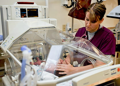 woman touching baby inside the incubator inside the hospital room thumbnail