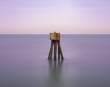 brown wooden stand on body of water at daytime thumbnail