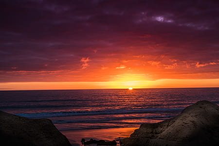 seashore near rocks at sunset thumbnail