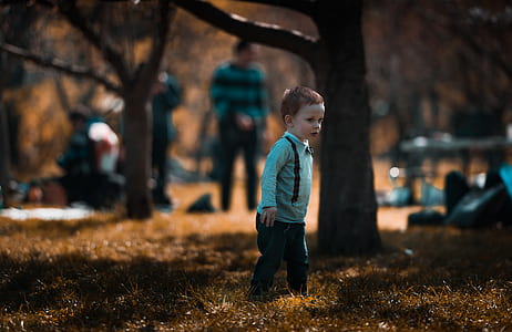 boy standing on brown grasses thumbnail