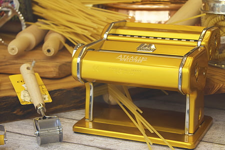 brass-colored pasta maker on white wooden surface thumbnail