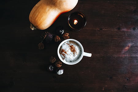 white ceramic mug beside orange pumpkin on top of brown wooden surface thumbnail
