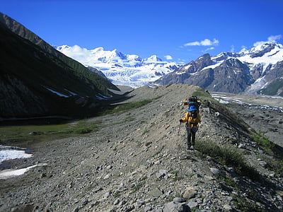 person walking on mountain under blue sky thumbnail