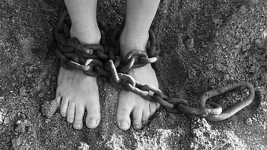 grayscale photography of person with chain on both feet thumbnail