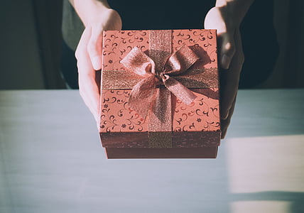 person holding orange gift box thumbnail