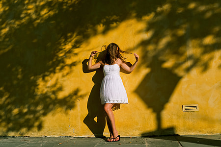 A woman standing wearing a white dress thumbnail
