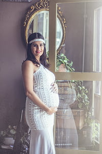 woman in white halter top standing near the mirror thumbnail