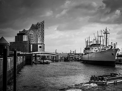 boat on body of water near gray concrete bridge thumbnail