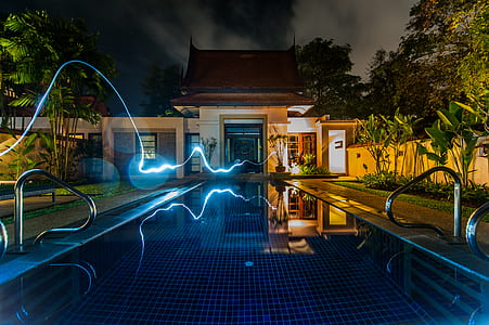 time laps photography of light crossing outdoor pool thumbnail