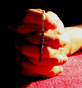 person praying while holding crucifix pendant necklace thumbnail