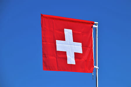 raised red and white cross flag during daytime thumbnail