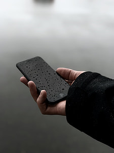 person holding iPhone with water droplets thumbnail