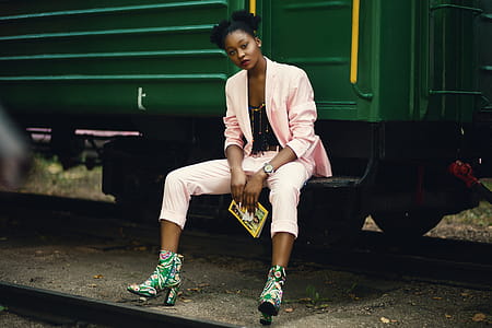 Woman in Pink Blazer Sitting on Green Train thumbnail