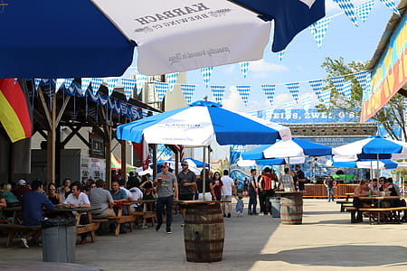 People Walking Beside Blue Patio Umbrella thumbnail