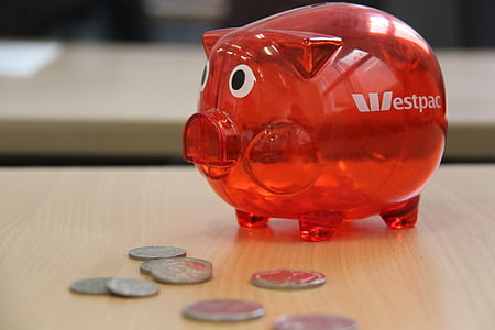 red Estpac coin bank on brown wooden table thumbnail