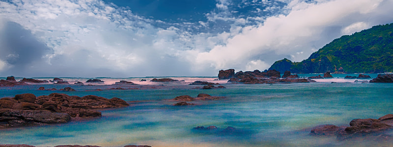 clear blue sea surrounded by rocks under clear blue sky thumbnail