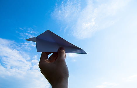 person holding paper plane during daytime thumbnail