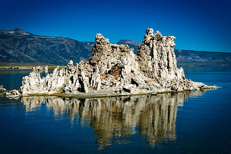 rock formation on body of water at daytime thumbnail
