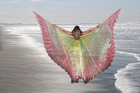 woman wearing dress with wings flying above the sea thumbnail