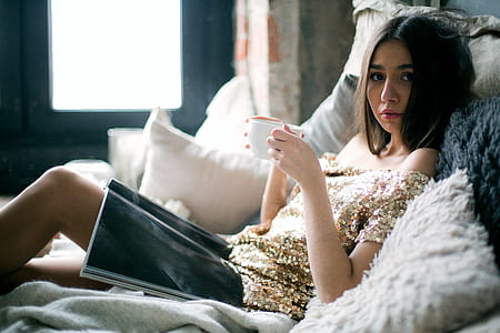 Woman in Sequinned Beige Off-shoulder Dress Laying on Bed thumbnail
