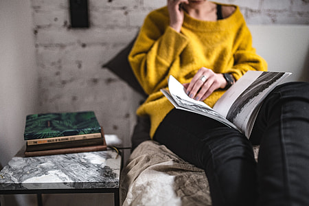 Young woman reading a magazine in bed thumbnail