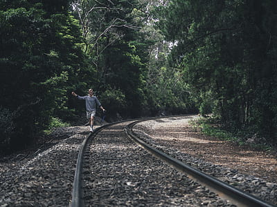 man walking on side of train track thumbnail