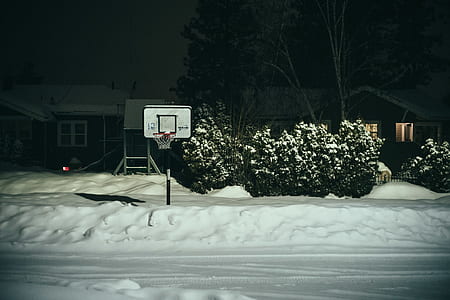 white and black basketball hoop covered with snow thumbnail