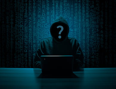 person in gray hoodie using computer inside dark room thumbnail